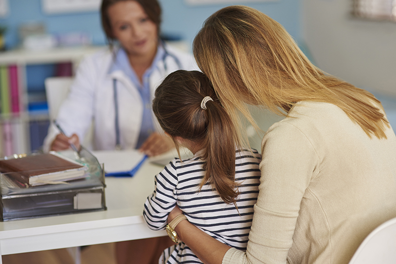 Moeder en kind op consultatie bij de arts die de zorg voor de intestinale gezondheid illustreert