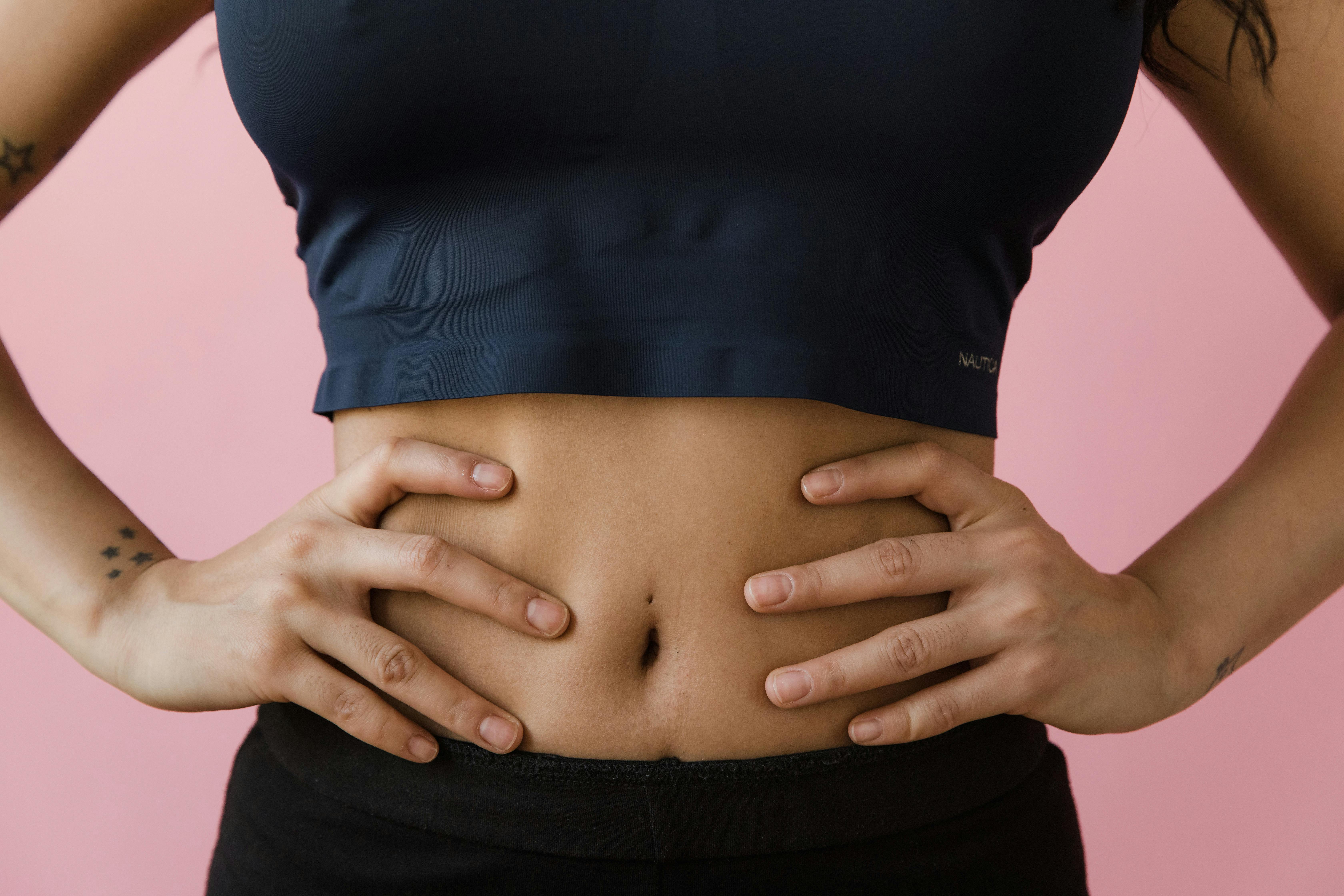 Vrouw met handen op de buik die intestinale balans en het welzijn van de darmflora illustreert