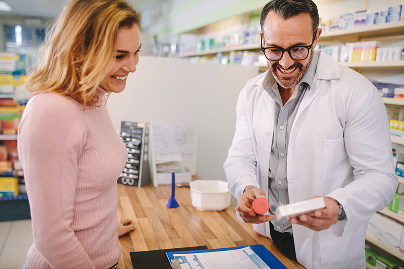 een vrouw bij haar apotheker, die haar een geschikt probioticum aanbeveelt