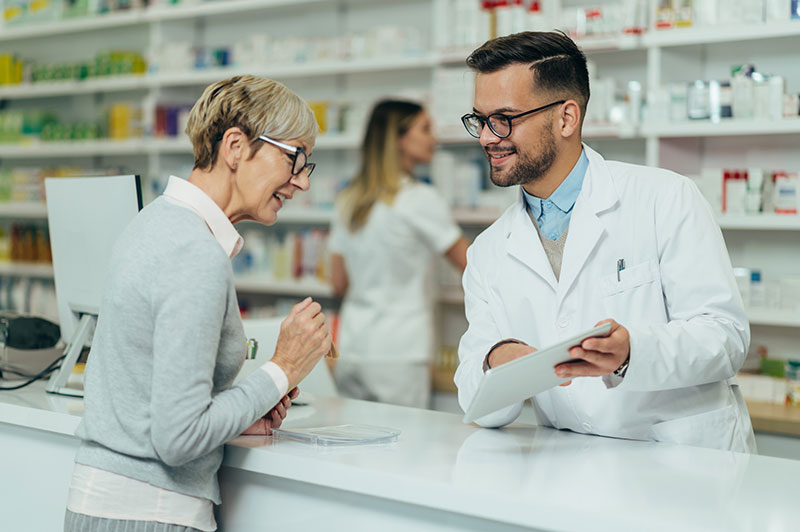 Vrouw die bij haar apotheker advies inwint over probiotica